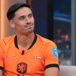 Tijjani Reijnders in een oranje voetbalshirt tijdens een rustig televisiegesprek.