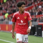 JJ Gabriel in het tenue van Manchester United op een voetbalveld.