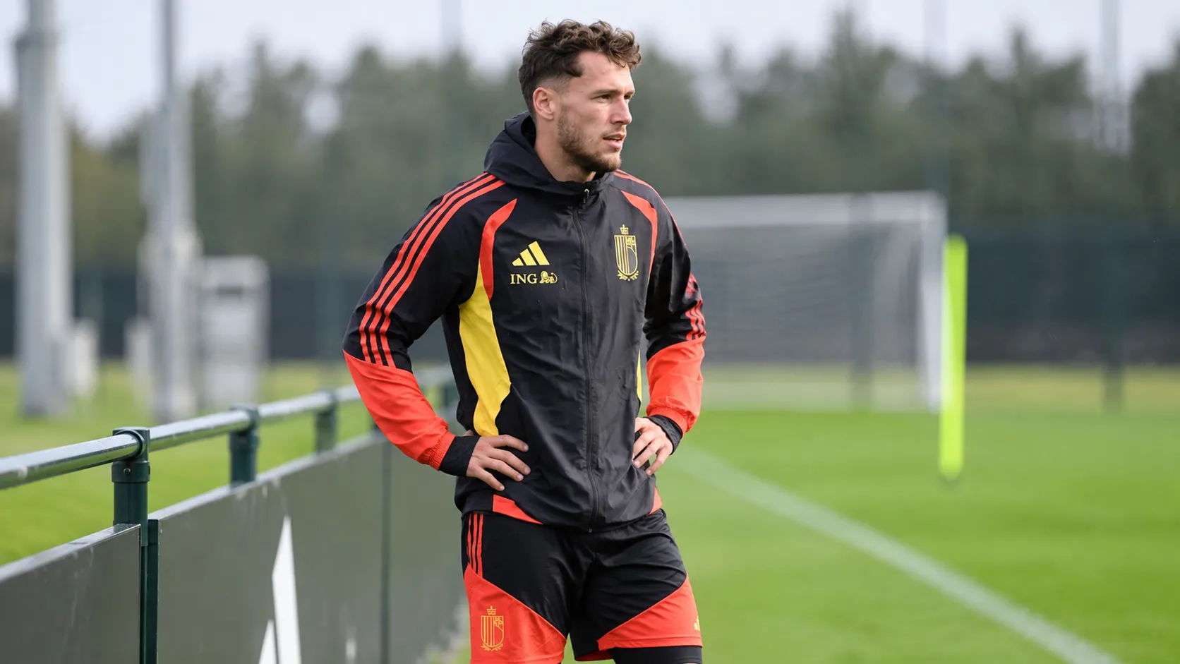 Lucas Stassin in Belgische trainingskleding aan de rand van een trainingsveld.