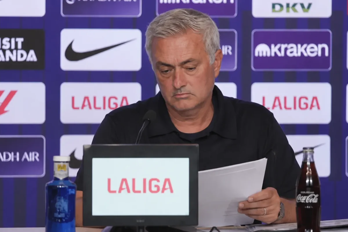 Javier Tebas aan een La Liga-perstafel terwijl hij notities bekijkt.