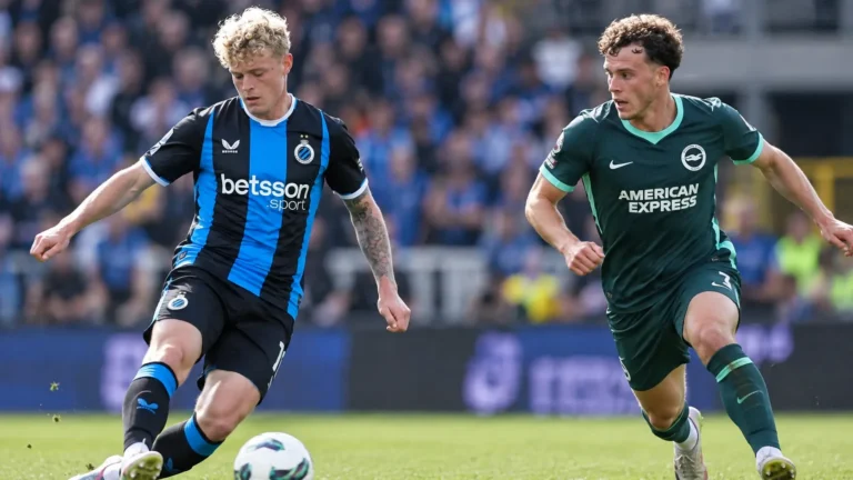 Twee voetballers in verschillende clubtenues tijdens wedstrijdactie.