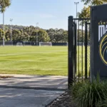 Leeg trainingsveld van Central Coast Mariners met het clubembleem op een vast toegangsbord.