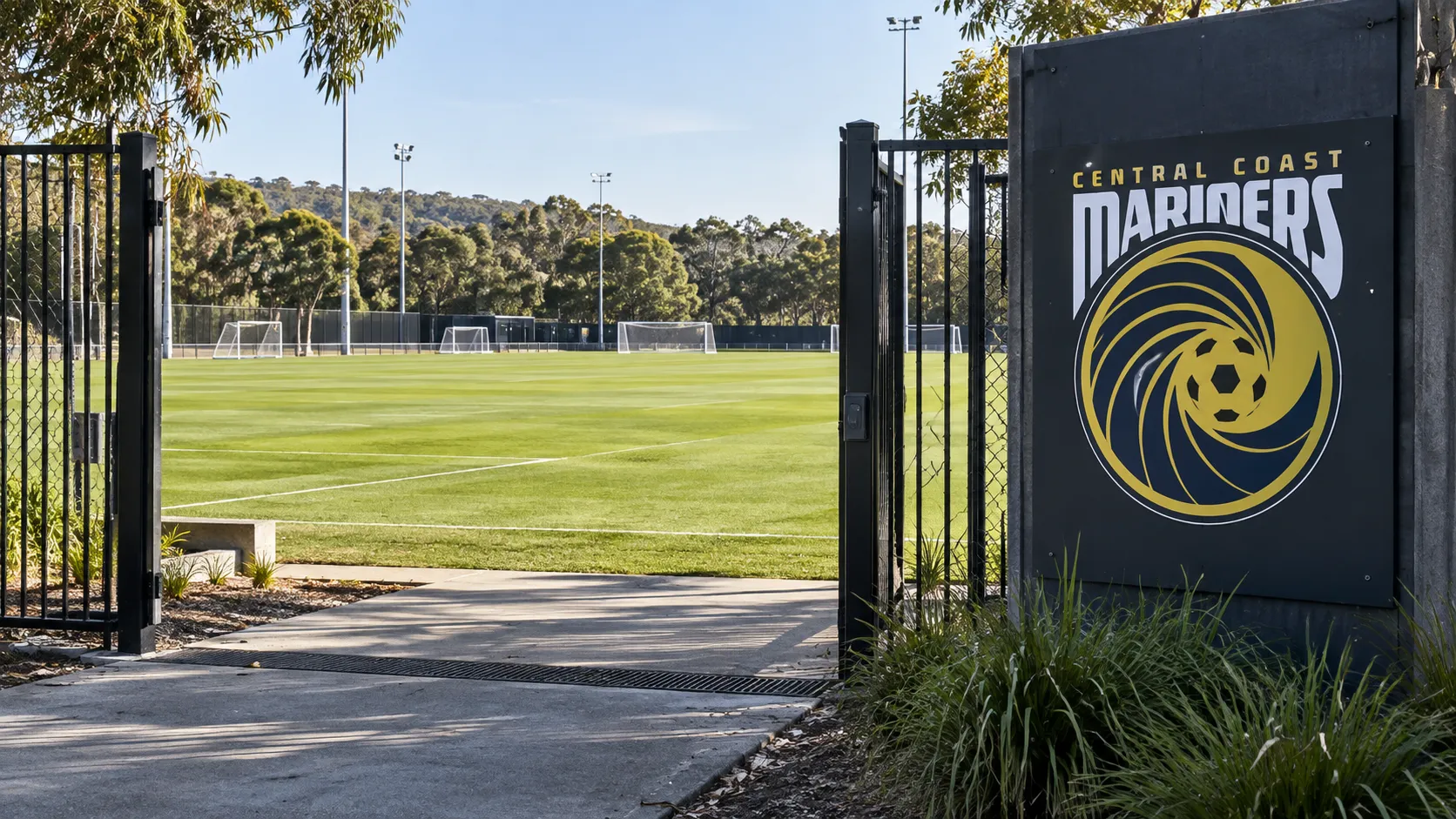 Leeg trainingsveld van Central Coast Mariners met het clubembleem op een vast toegangsbord.