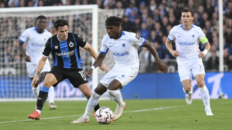 Voetballers strijden om de bal tijdens een wedstrijd in een Belgisch stadion.