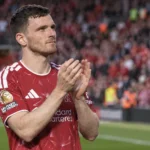 Andy Robertson applaudisseert in het Liverpool-tenue op het veld.