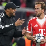 Een Bayern München-coach en een speler in rood tenue aan de zijlijn van een stadion.