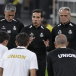 Spelers en stafleden van Union SG vormen een hechte kring aan de rand van het veld.