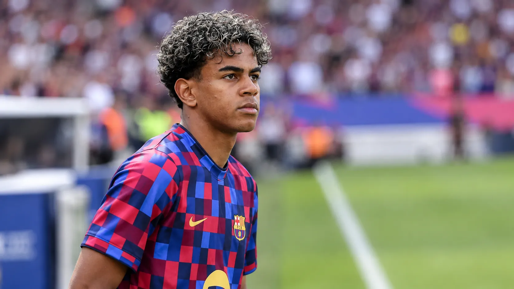 Lamine Yamal in het shirt van FC Barcelona langs de zijlijn.