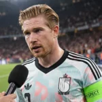 Kevin De Bruyne in Belgisch shirt tijdens een televisie-interview aan de rand van het stadion.