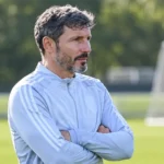 Mark van Bommel kijkt geconcentreerd toe langs een trainingsveld.