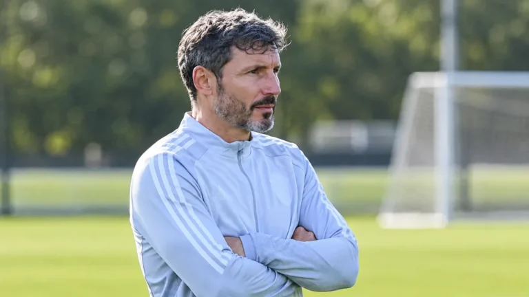 Mark van Bommel kijkt geconcentreerd toe langs een trainingsveld.