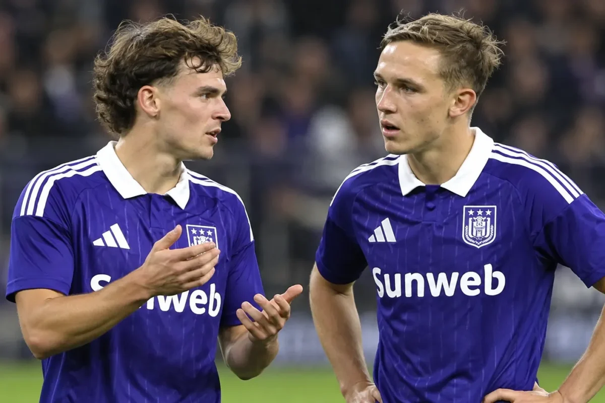 Twee Anderlecht-spelers in paars-blauwe wedstrijdkleding op het veld van Lotto Park.