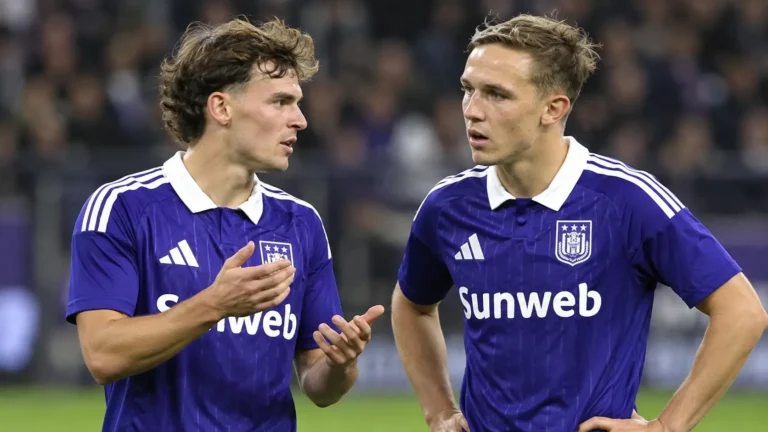 Twee Anderlecht-spelers in paars-blauwe wedstrijdkleding op het veld van Lotto Park.