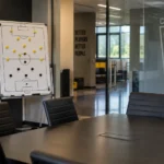 Lege videoruimte van Columbus Crew met een tactiekbord en een clubembleem op de glazen wand.