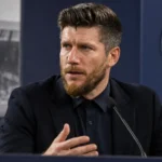 Sébastien Pocognoli spreekt in een mediaruimte van de Schotse nationale ploeg.