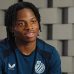 Wisdom Mike tijdens een interview in een donkerblauw Club Brugge-shirt.