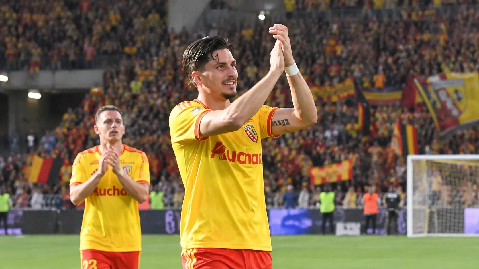 Franjo Ivanovic in het gele tenue van RC Lens op het veld na een wedstrijd.
