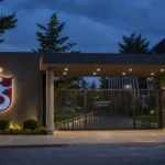 Verlichte ingang van het clubkantoor van Trabzonspor met het clubembleem op de gevel.