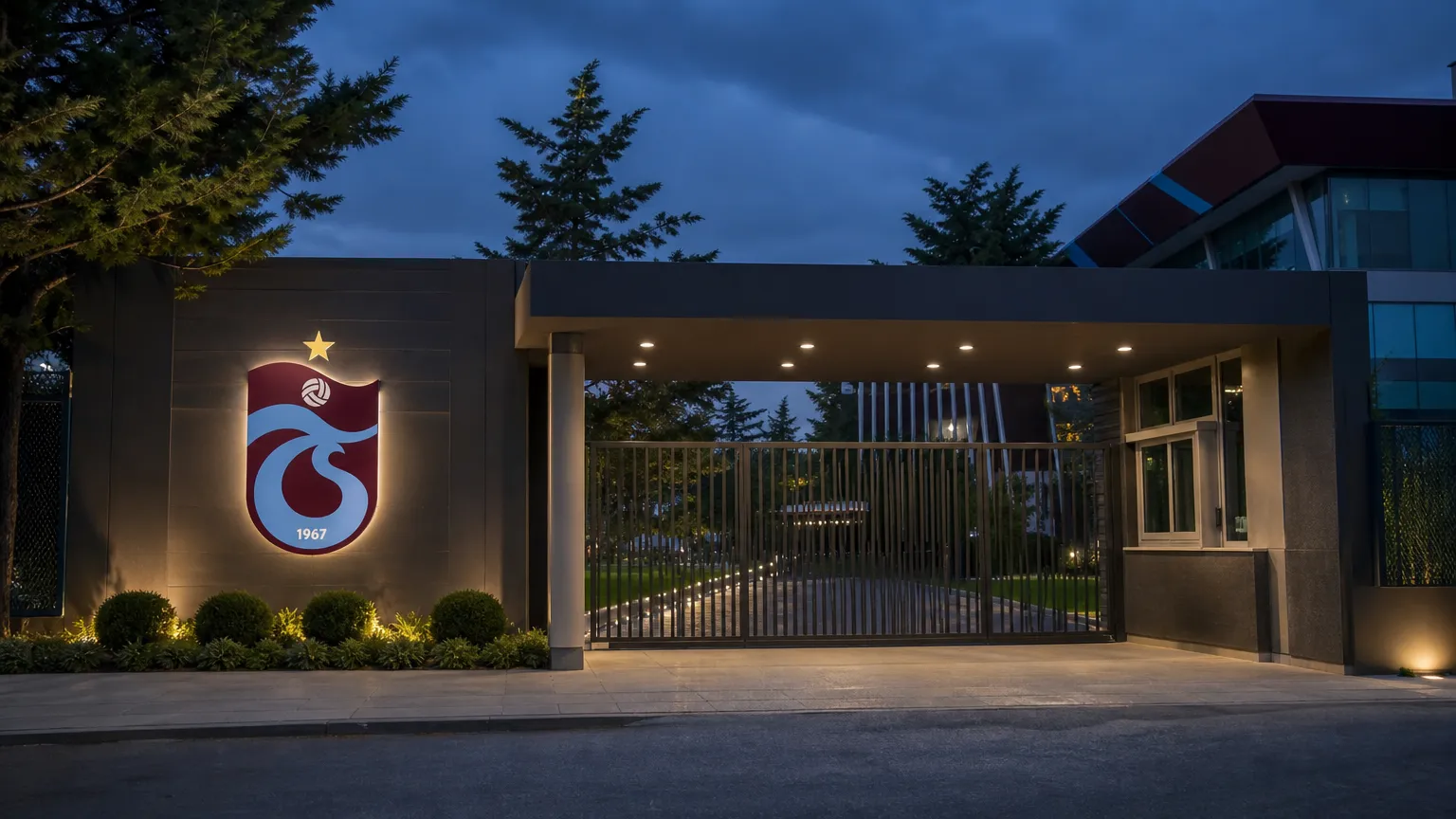 Verlichte ingang van het clubkantoor van Trabzonspor met het clubembleem op de gevel.