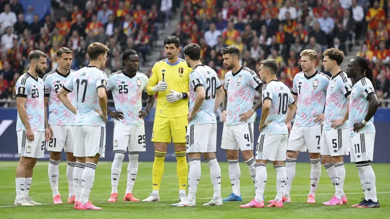 Een groep Belgische internationals in wedstrijdtenue verzameld op het veld voor een interland.