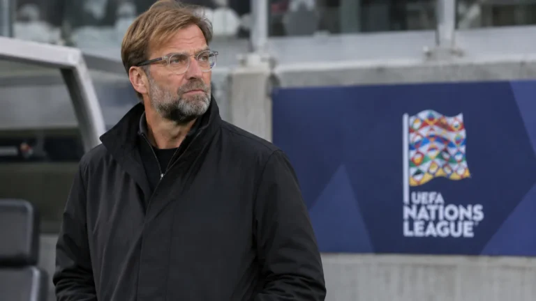 Jürgen Klopp in een rustige technische zone van een stadion naast een discreet Nations League-bord.