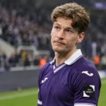 Yari Verschaeren applaudisseert in een paars wedstrijdshirt aan de rand van het veld.
