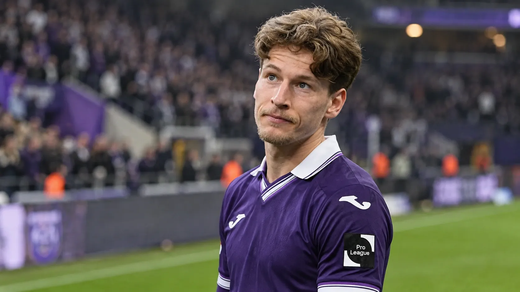 Yari Verschaeren applaudisseert in een paars wedstrijdshirt aan de rand van het veld.