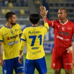 STVV-spelers in gele tenues en hun doelman vieren samen op het veld.