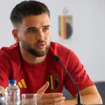 Nicolas Raskin spreekt tijdens een mediamoment in zijn rode shirt van België.