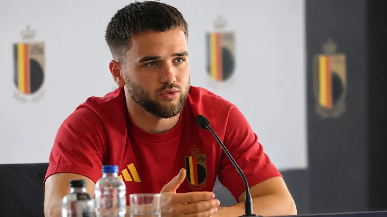 Nicolas Raskin spreekt tijdens een mediamoment in zijn rode shirt van België.