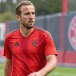 Harry Kane in het rode tenue van Bayern München tijdens een rustige warming-up op het trainingsveld.