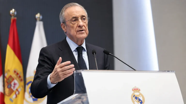 Een niet-spelende clubofficial spreekt aan een podium met zichtbaar Real Madrid-embleem.