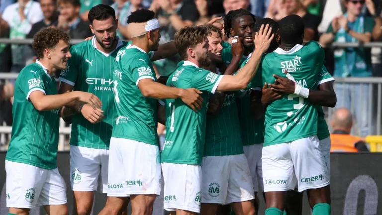 Een groep Lommel-spelers viert samen naast het veld in groene wedstrijdtenues.