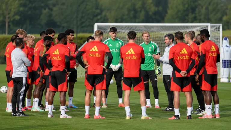 Groep spelers en staf tijdens een training op een voetbalveld.