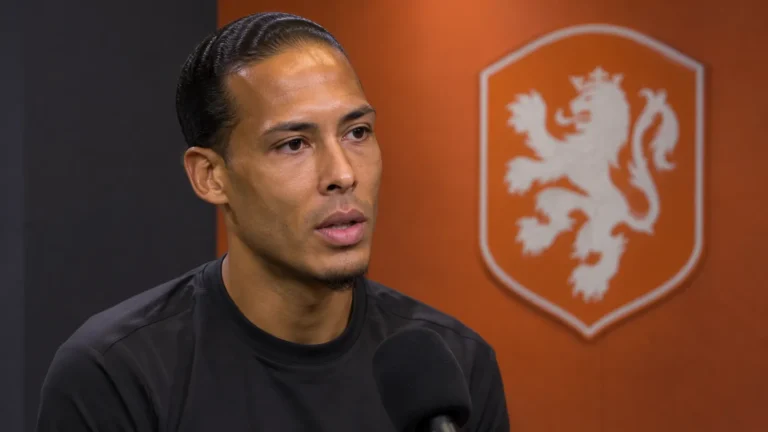 Virgil van Dijk beantwoordt een vraag in een neutrale mediazone met een Nederlands elftalembleem op de wand.