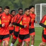 Een groep Rode Duivels loopt een warming-up op het trainingsveld.