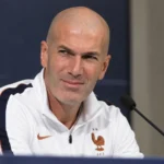 Zinedine Zidane kijkt tijdens een persconferentie rustig naar een journalist buiten beeld.