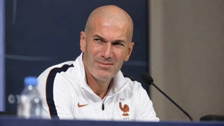 Zinedine Zidane kijkt tijdens een persconferentie rustig naar een journalist buiten beeld.