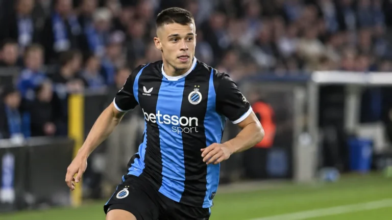Een speler van Club Brugge warmt op aan de rand van het veld.