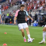 Drie Belgische internationals warmen op op een voetbalveld.