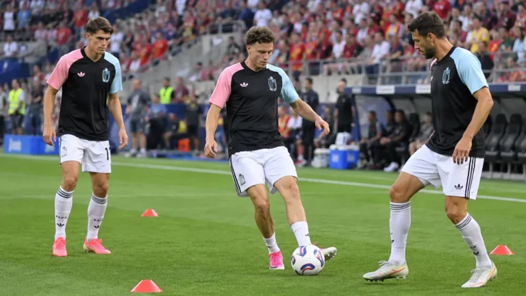 Drie Belgische internationals warmen op op een voetbalveld.