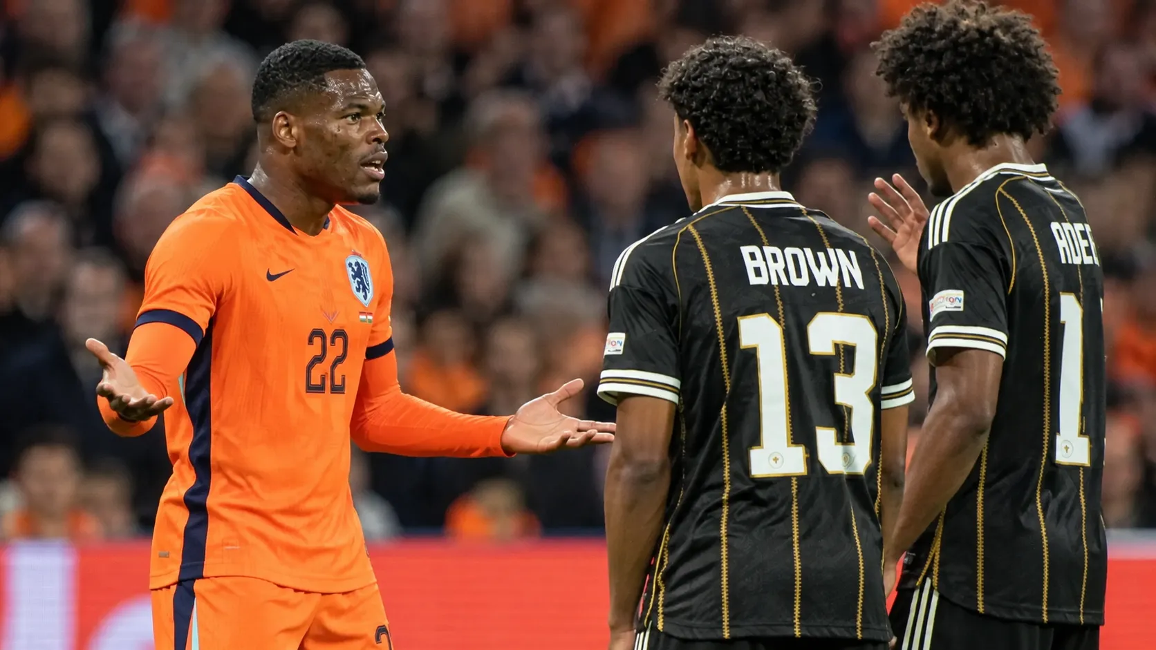 Denzel Dumfries gebaart naar twee Duitse spelers tijdens de wedstrijd.