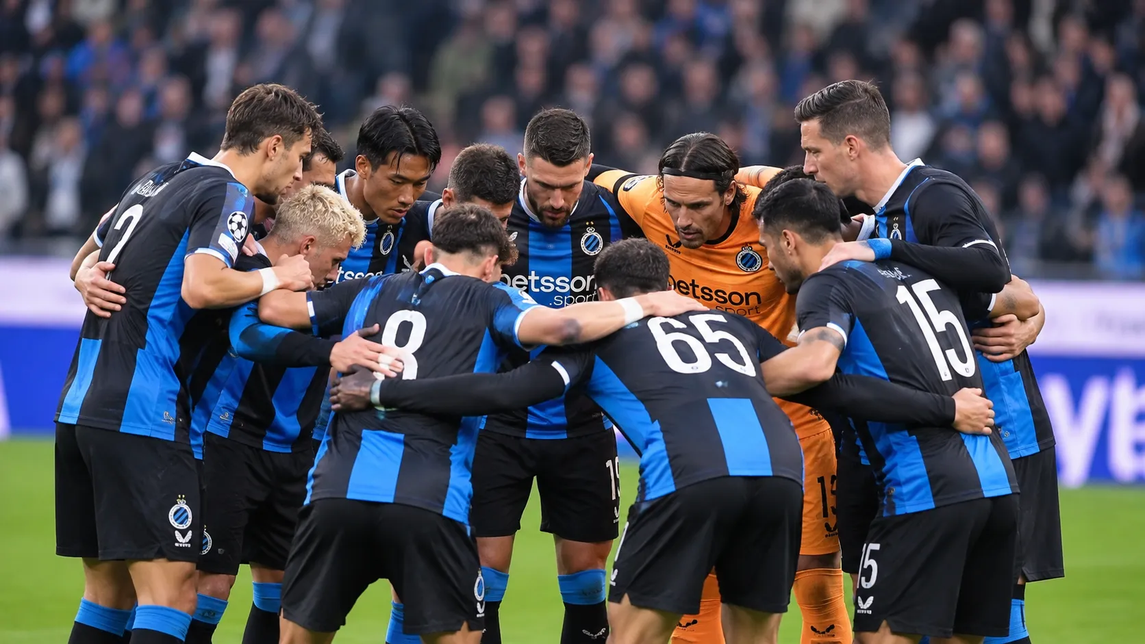 Een groep Club Brugge-spelers vormt vlak voor een wedstrijd een huddle op het veld.