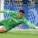 Lucca Brughmans in groen doelmanstenue tijdens een redding voor KRC Genk.