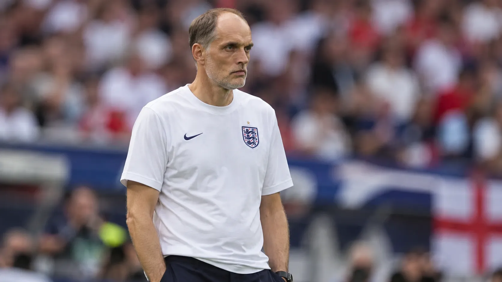 Thomas Tuchel in een wit Engeland-shirt langs de zijlijn.