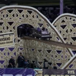 Grote tifo met een kleine achtbaanconstructie op een stadiontribune.