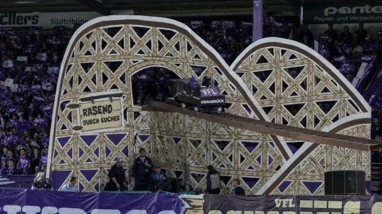 Grote tifo met een kleine achtbaanconstructie op een stadiontribune.