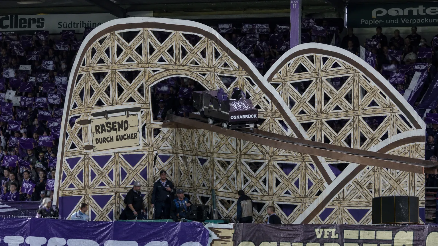 Grote tifo met een kleine achtbaanconstructie op een stadiontribune.