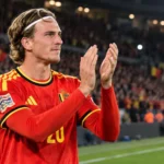 Mika Godts applaudisseert na de wedstrijd in het rode shirt van België.