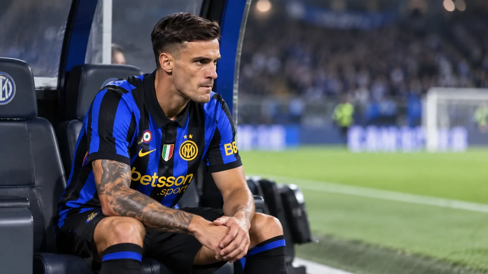 Aleksandar Stankovic in Inter-tenue op de bank naast het veld.